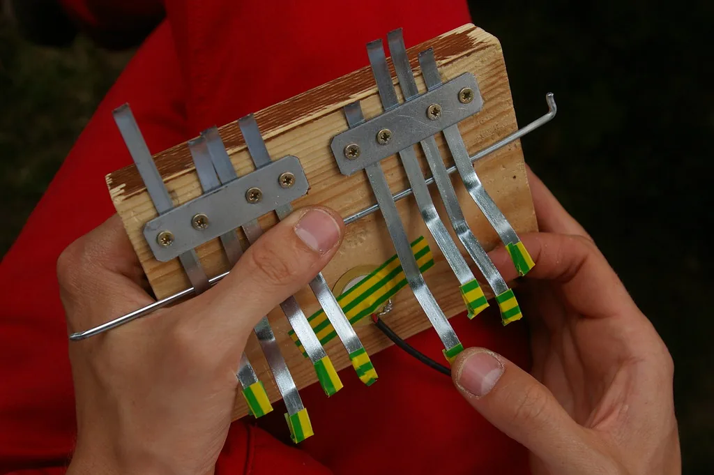 Hands playing a handcrafted kalimba Hands playing a handcrafted kalimba