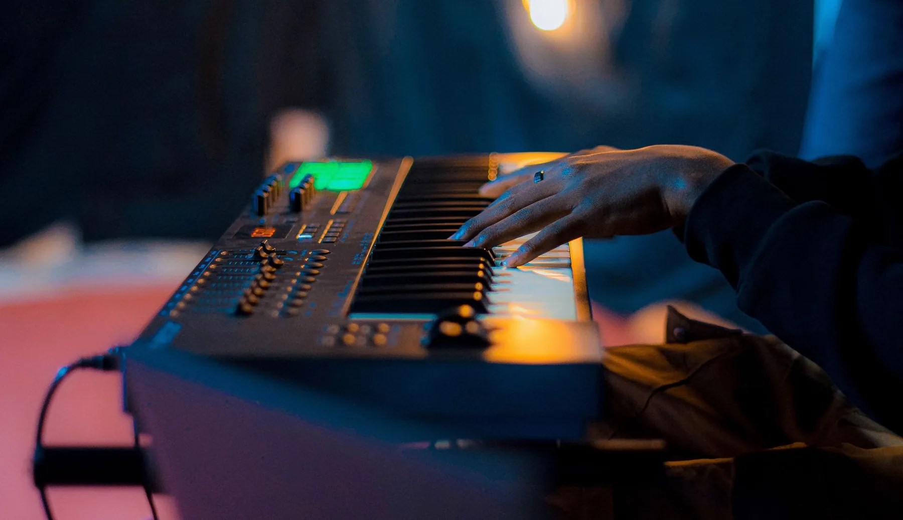 Hands playing a bright musical keyboard Hands playing a bright musical keyboard