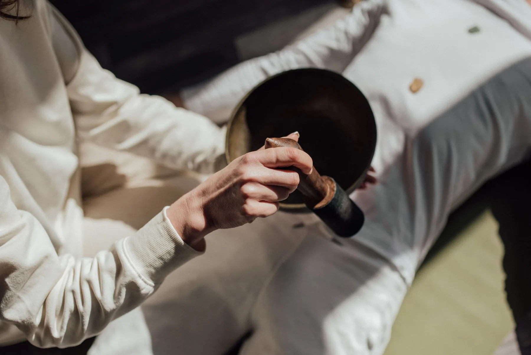 Person playing a Tibetan singing bowl Person playing a Tibetan singing bowl