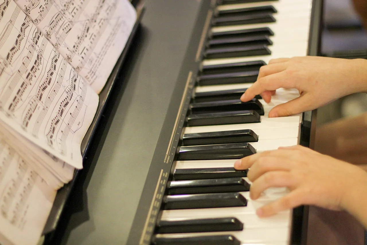 hands playing piano with sheet music hands playing piano with sheet music