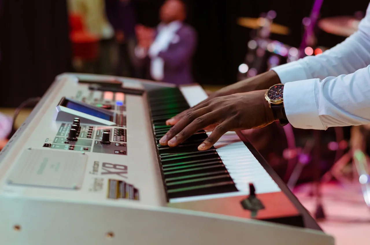 Musician playing a keyboard on stage Musician playing a keyboard on stage