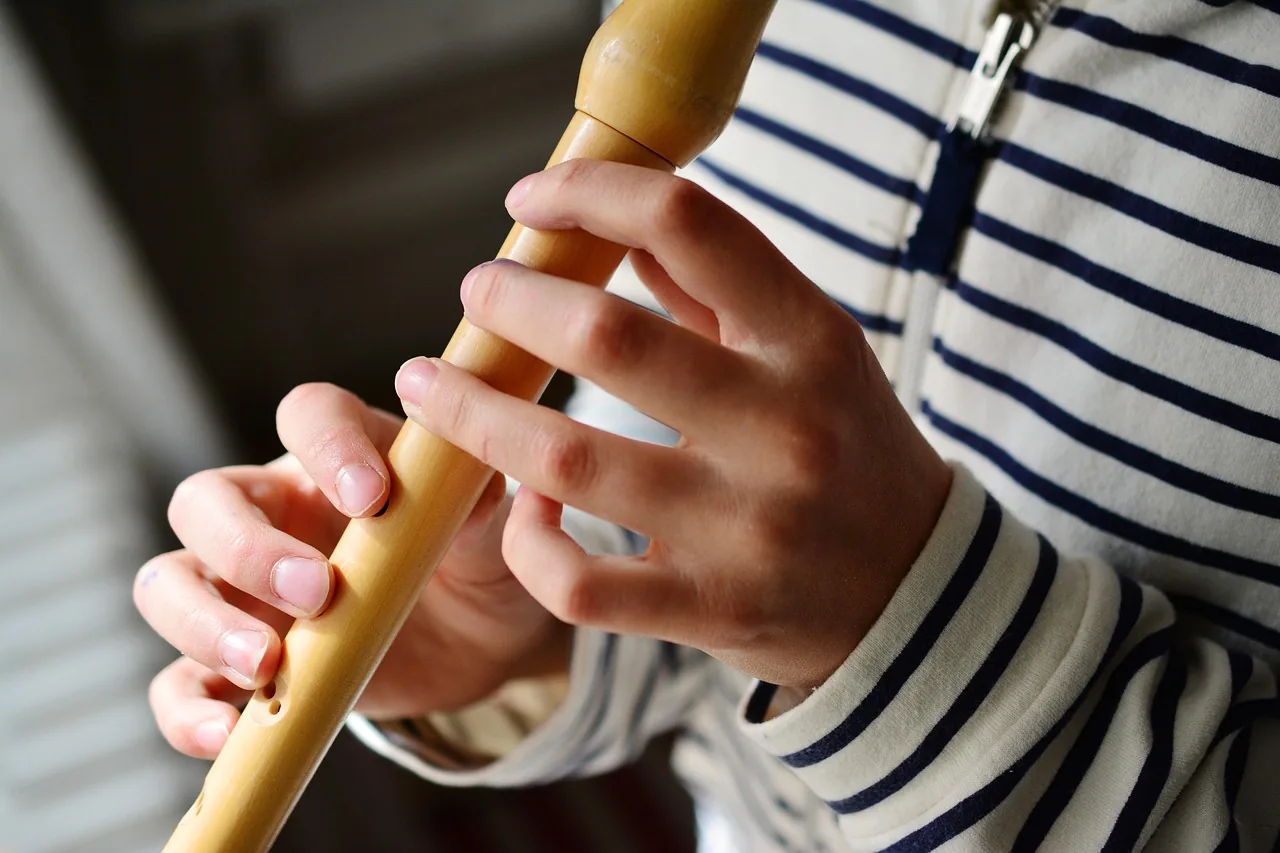 Hands playing a wooden flute Hands playing a wooden flute