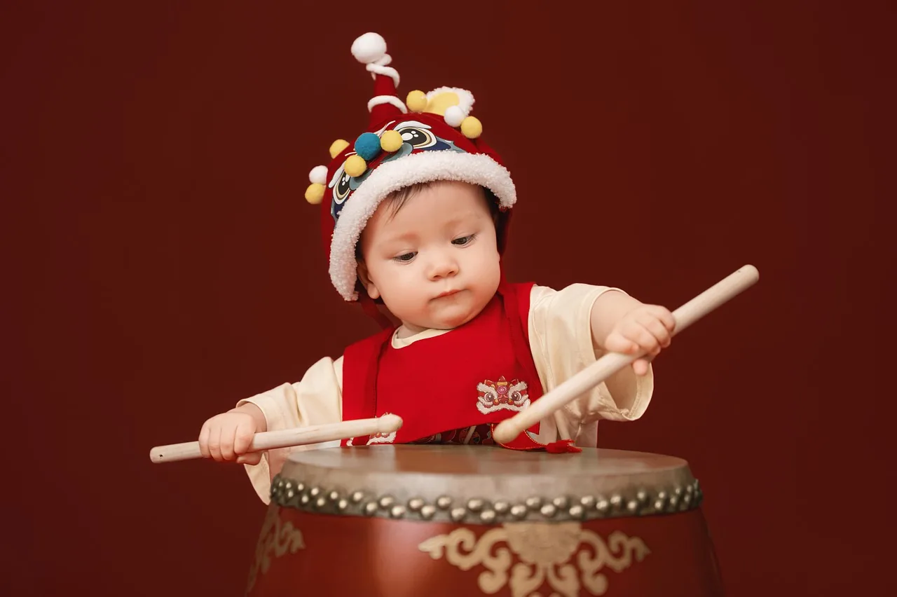 child playing a red drum child playing a red drum